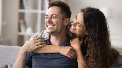 Close up smiling Latina woman hugging her beloved handsome husband, showing affection and love, enjoy moment of tenderness, enjoy their warm relationship, spend time together at home. Family, relation