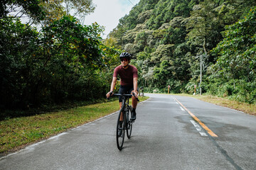 A young woman riding her bicycle in the mountains.