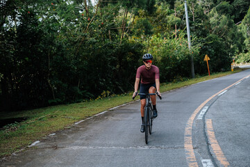 A young woman riding her bicycle in the mountains.