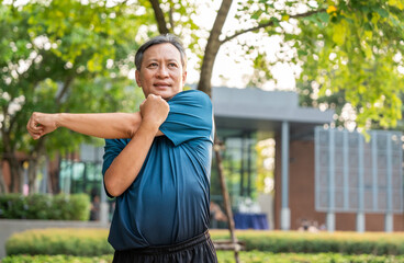 Senior old asian man wearing sportswear warming up before running outdoor. Portraits of Mature man stretching body before running at public park. Training athlete work out at outdoor nature