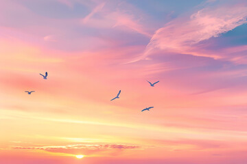 Obraz premium Peaceful Morning Sunrise with Birds Flying Across Pink and Orange Sky
