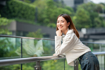 Young asian woman fashion lifestyle with headphone standing posing in urban city downtown. Happy...