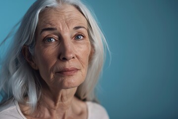 Empowered senior woman portrait against blue background. Active aging concept.