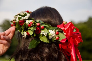 Naklejka premium Foto di una corona di alloro con fiori bianchi e rossi e fiocco rosso