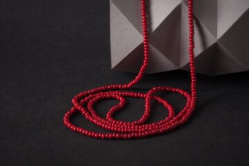 A necklace of red bead on a black background