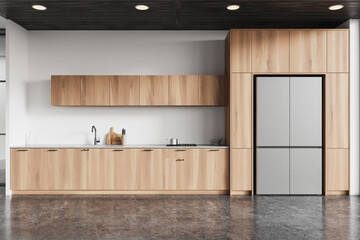 Home kitchen interior with wooden cabinet and refrigerator, concrete floor