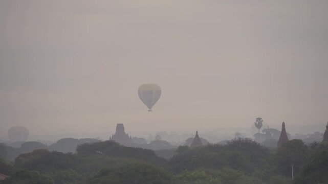 Balloons flying over Burmese temples of Bagan City from a balloon, unesco world heritage with forest trees, Myanmar or Burma. Tourist destination.
