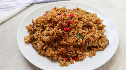 indonesian fried rice with goat meat (nasi goreng kambing) served on a plate. A plate of fried rice with lamb.
