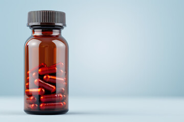 Close-up image of a brown glass bottle filled with red capsules on a light blue background. Perfect for medical, pharmaceutical, or healthcare related concepts.