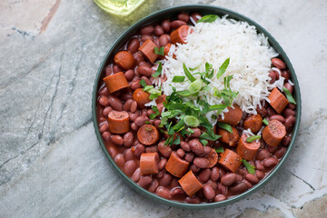 Red beans with sausages and white rice, horizontal shot on a grey granite background, elevated view
