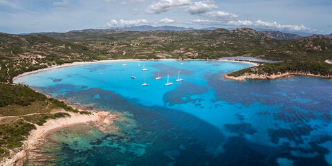 Aerial view of yachts moored in the turquoise Mediterranean sea at the bay of Rondinara on the island of Corsica