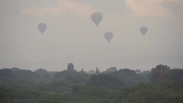 Balloons flying over Burmese temples of Bagan City from a balloon, unesco world heritage with forest trees, Myanmar or Burma. Tourist destination.