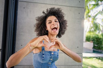Portrait of a young cheerful woman of African descent standing in a modern luxury villa. Exotic and...