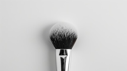 Stylish black and silver-handled professional makeup brush on a clean white surface, ideal for beauty tasks
