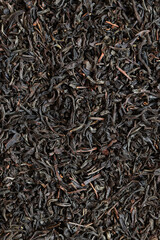 Long black tea, texture. Top view of dried tea leaves. Tea composition. Ingredients for a hot drink, close-up. Background