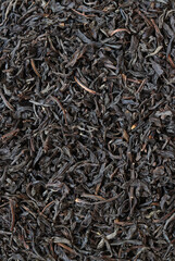 Long black tea, texture. Top view of dried tea leaves. Tea composition. Ingredients for a hot drink, close-up. Background