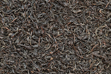 Long black tea, texture. Top view of dried tea leaves. Tea composition. Ingredients for a hot...