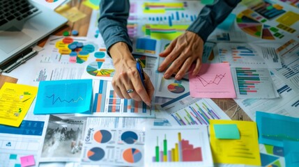A business analyst conducting market research with charts, graphs, and reports spread out on a conference table.
