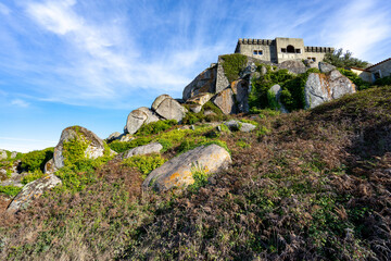 Part of the Peninha Palace in Sintra seen from below with rocks in the foreground.