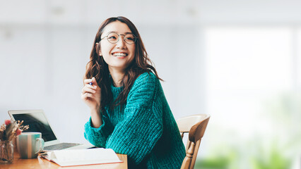デスクワークをする笑顔の日本人女性