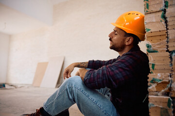 Exhausted construction worker resting on the floor.