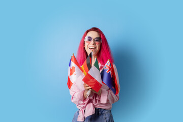 Woman with pink hair and different flags on blue background, international school teacher, language...