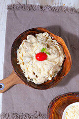 Creamy Alfredo fettuccine pasta topped with fresh herbs isolated
