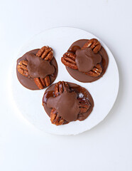 Chocolate covered walnut. Delicious nutritious nut candies falling into a rotating wooden bowl