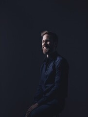 Obraz premium Smiling Male Executive Posing Against Dark Minimalistic Background