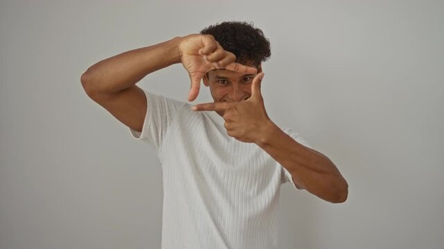 Young latin man wearing white t-shirt framing with hands and fingers over isolated background making happy face for photography creativity concept photo