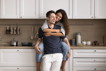 Beautiful just married couple spend carefree leisure in modern renovated cozy kitchen. Happy homeowners family tenants relaxing in own or rented house. Accommodation, harmonic relationships, marriage