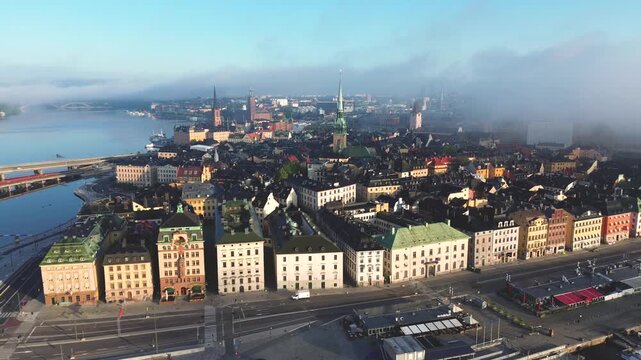 Right panning aerial view of Gamla Stan in Stockholm, Sweden with clearing morning mist in summer 