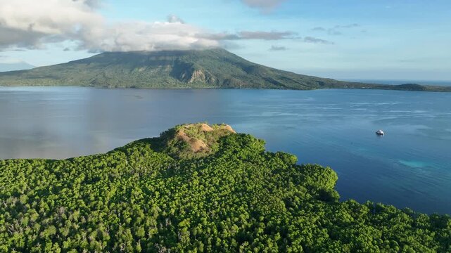 Morning sunlight illuminates the mangrove-fringed island of Lembata, Indonesia. This beautiful and biodiverse area is part of the famed Ring of Fire and is home to high marine biodiversity.