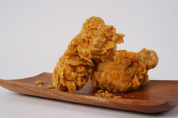 Delicious crispy fried chicken. Fried chicken drumstick on wooden plate. Fried Chicken food photography in white background. Hot Crispy Chicken Nuggets, Fillet Strips, Meat Pieces.
