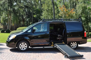 Fototapeta premium A wheelchair accessible minivan is parked outside with an open door and an extended ramp.