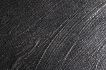Superficie con texture materica molto irregolare dipinta di colore grigio-nero; spazio per testo