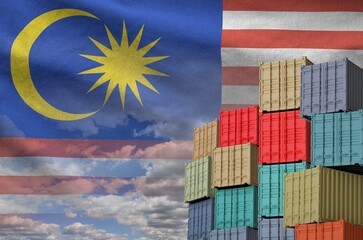 Malaysia flag and big stack of shipping cargo containers in docks with sky background close up