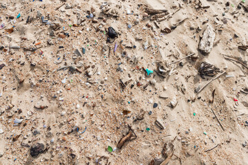 Microplastic rubbish on coastline. Plastic garbage in sand on ocean beach.