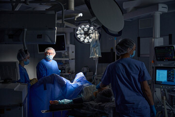 Group of surgeons in operating room with surgical laparoscopy equipment