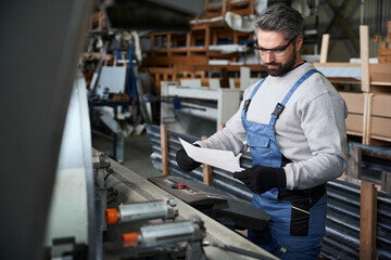Specialist with working documentation at the workplace in the workshop