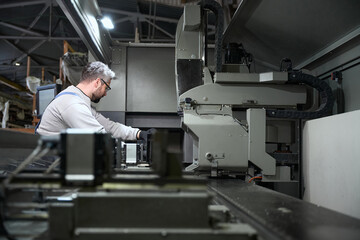 Man works on modern equipment in a production workshop