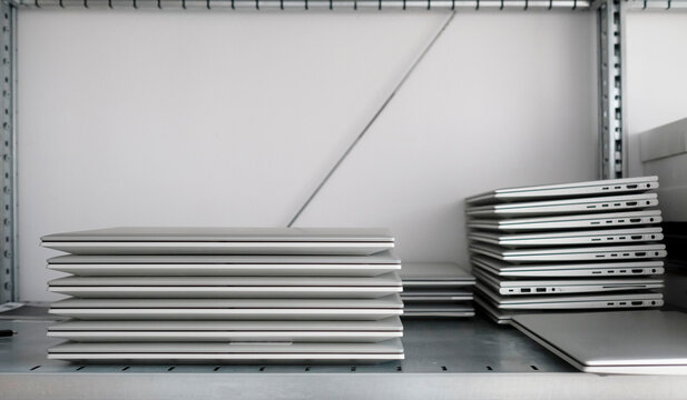 Rack with a stack of laptops in the storage room of a company