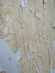 Cracked yellow paint on the wall as an abstract background. Texture
