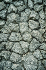 Empty light green grey embossed stone wall for abstract background and texture for interior or exterior design. Beautiful patterns, space for work, banner, wallpaper close up.Vertical.