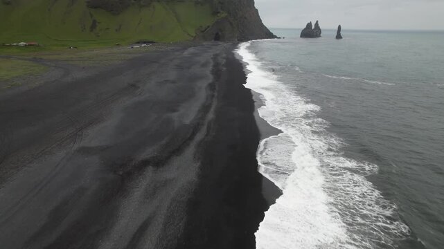 drone aerial view of ocean waves in iceland on a black beach vik iceland