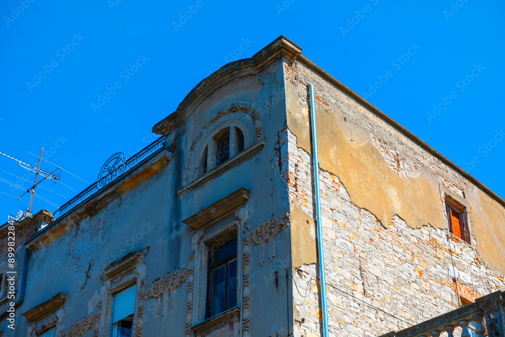 Wall mural old house with shabby wall in old town. building is old and has a lot of cracks in the wall