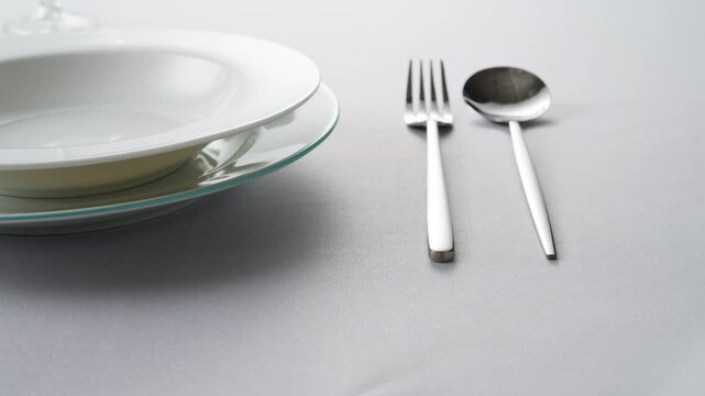 Fancy restaurant, waiter Elegant table setting with white square plate and silverware, arranged for sophisticated dining