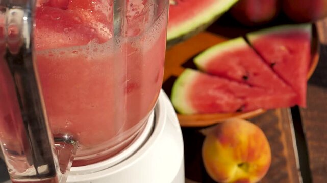 the process of mixing watermelon and peach pulp with grinding using a blender. Make a delicious fruit cocktail. Diet vegetarian smoothie with diuretic properties. Diet from drinks