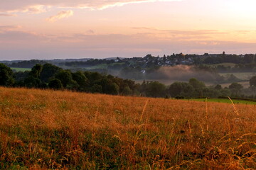 Abenddämmerung über blühenden Feldern zwischen Berg und Tal