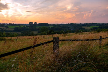 Abenddämmerung über blühenden Feldern zwischen Berg und Tal